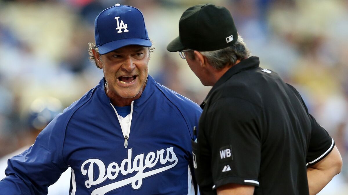 Dodgers Manager Don Mattingly, left, argues with home plate umpire Paul Nauert during a game against the Pittsburgh Pirates on May 30. Mattingly says he shouldn't have to go to umpires in order to issue a call challenge.