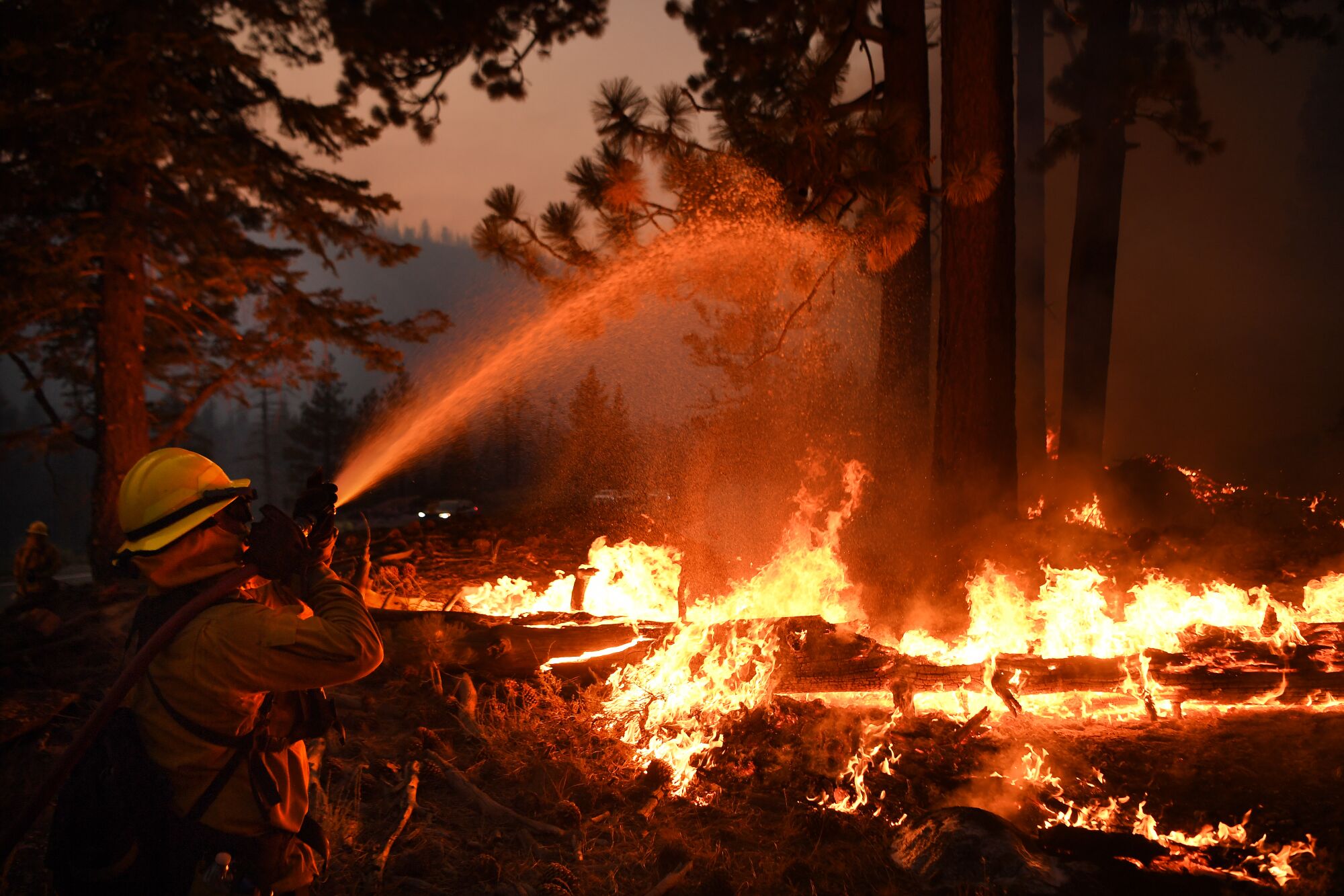 Firefighters battle the Caldor fire along Highway 89 west of Lake Tahoe on Thursday.