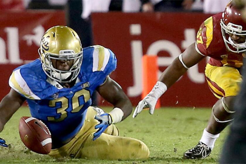 UCLA linebacker Myles Jack recovers a USC fumble during the Bruins' 35-14 win over the Trojans on Saturday at the Coliseum.