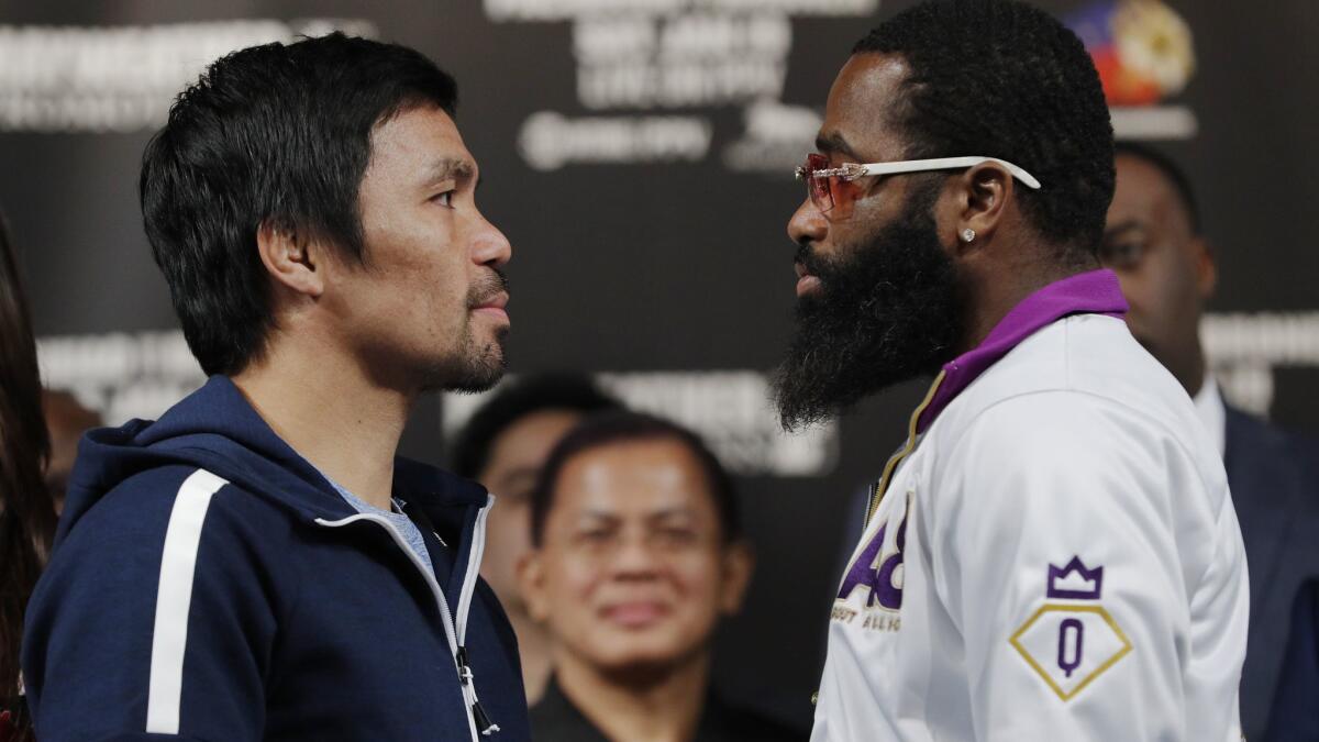 Manny Pacquiao, left, and Adrien Broner pose for photographers during a news conference on Wednesday in Las Vegas. The two are scheduled to fight in a welterweight championship bout on Saturday.