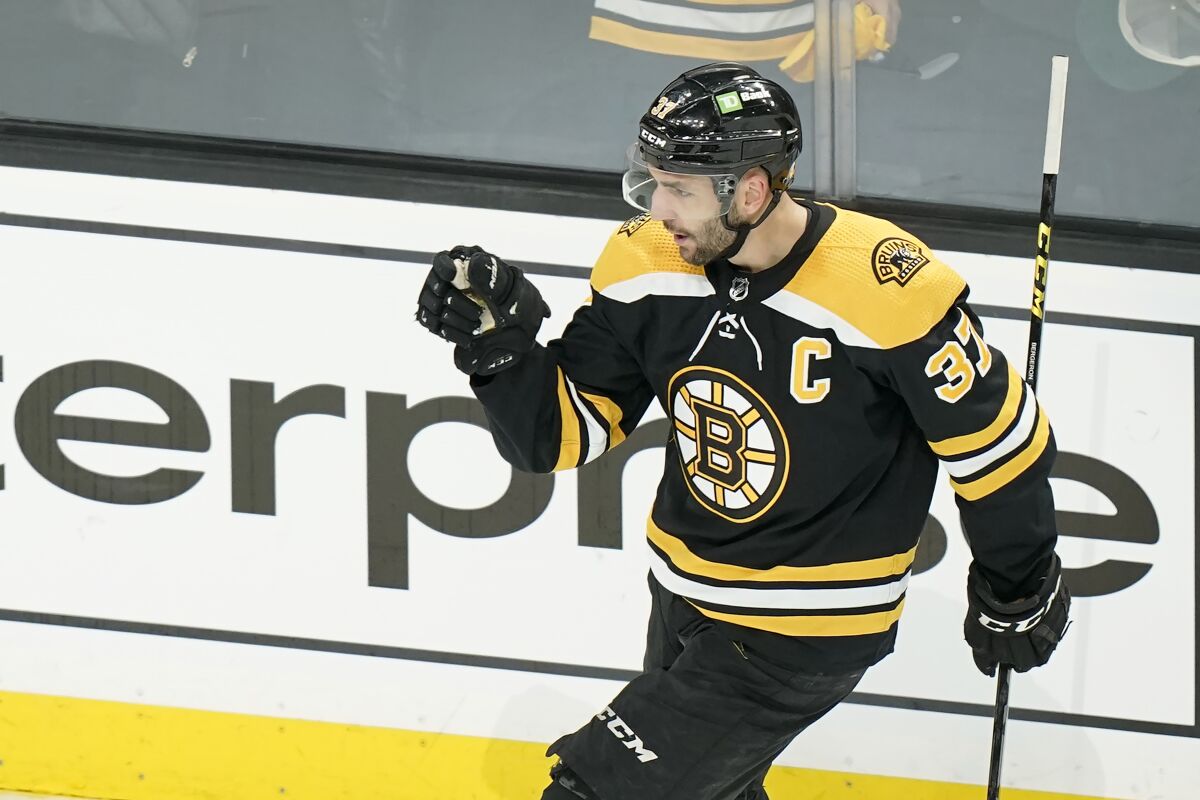 Boston Bruins' Patrice Bergeron (37) celebrates after scoring in the first period of Game 4 of an NHL hockey Stanley Cup first-round playoff series against the Carolina Hurricanes, Sunday, May 8, 2022, in Boston. (AP Photo/Steven Senne)