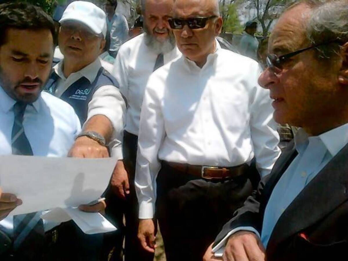 Borough President Victor Hugo Romo, left, looks over a document during a tour of Mexico City's wealthy Las Lomas neighborhood.
