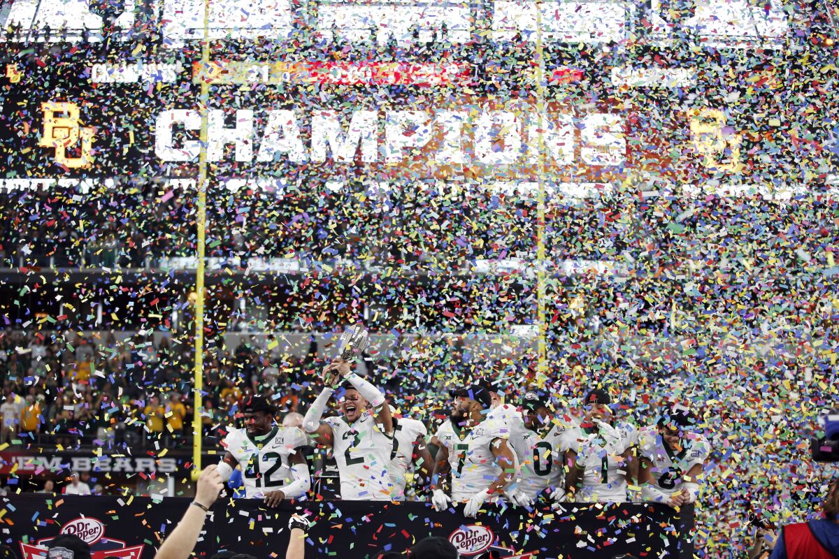 Baylor safety Jairon McVea (42), linebacker Terrel Bernard (2), running back Abram Smith (7), wide receiver R.J. Sneed (0) running back Trestan Ebner (1) and safety Jalen Pitre (8) celebrate with the trophy after defeating Oklahoma State in an NCAA college football game for the Big 12 Conference championship in Arlington, Texas, Saturday, Dec. 4, 2021. (AP Photo/Tim Heitman)
