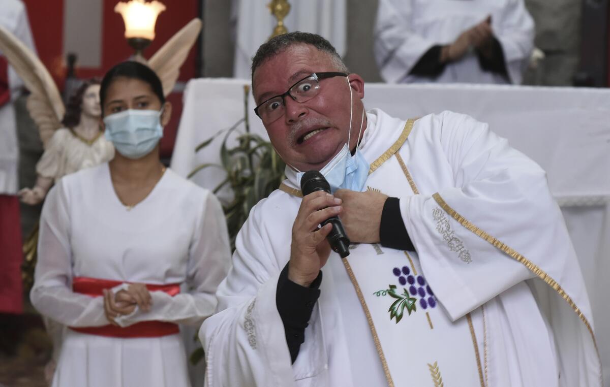 Sergio Valverde Espinoza, a Catholic priest of the Cristo Rey church who modified a popular song called "Sopa de Caracol," or Snail Soup in English, gestures during a Mass in San Jose, Costa Rica, Sunday, May 2, 2021. Valverde changed the song's lyrics to a message calling for the use of face masks and care during the pandemic. (AP Photo/Carlos Gonzalez)