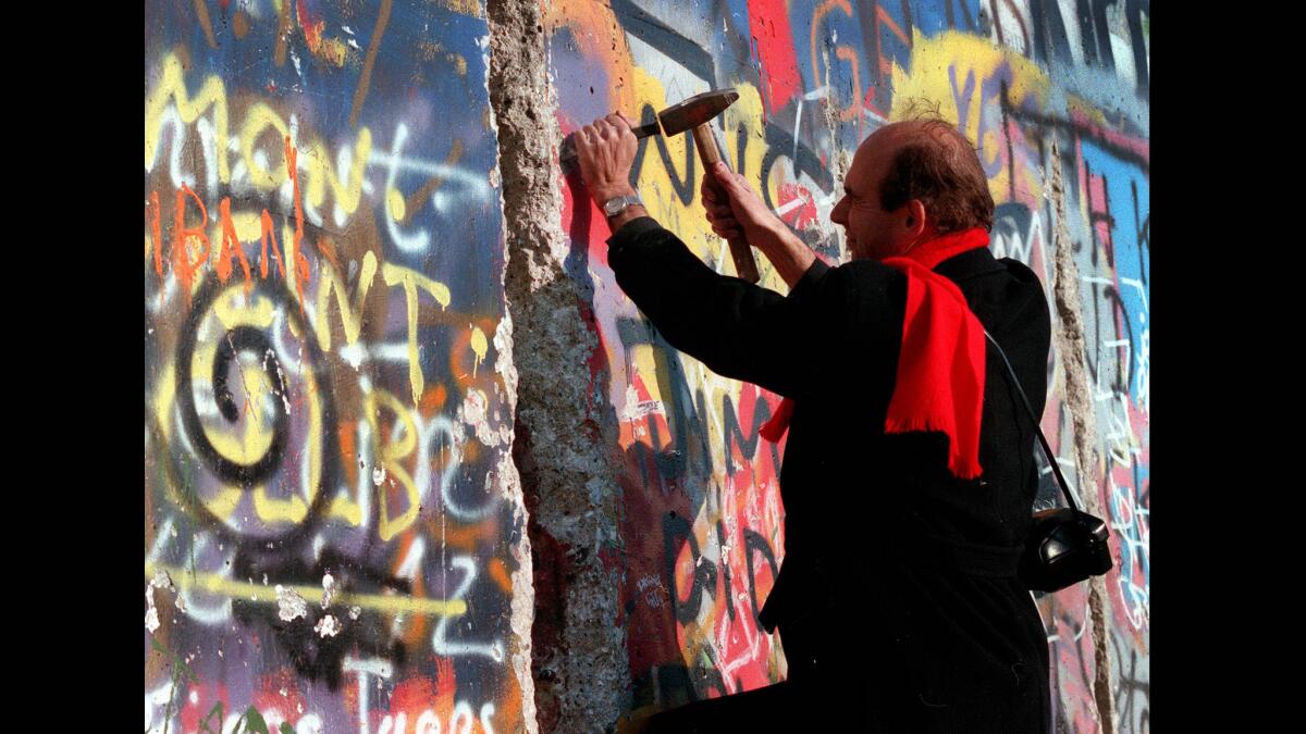 A man chips away at the Berlin Wall near the Brandenburg Gate on the West Berlin side on Nov. 10, 1989.