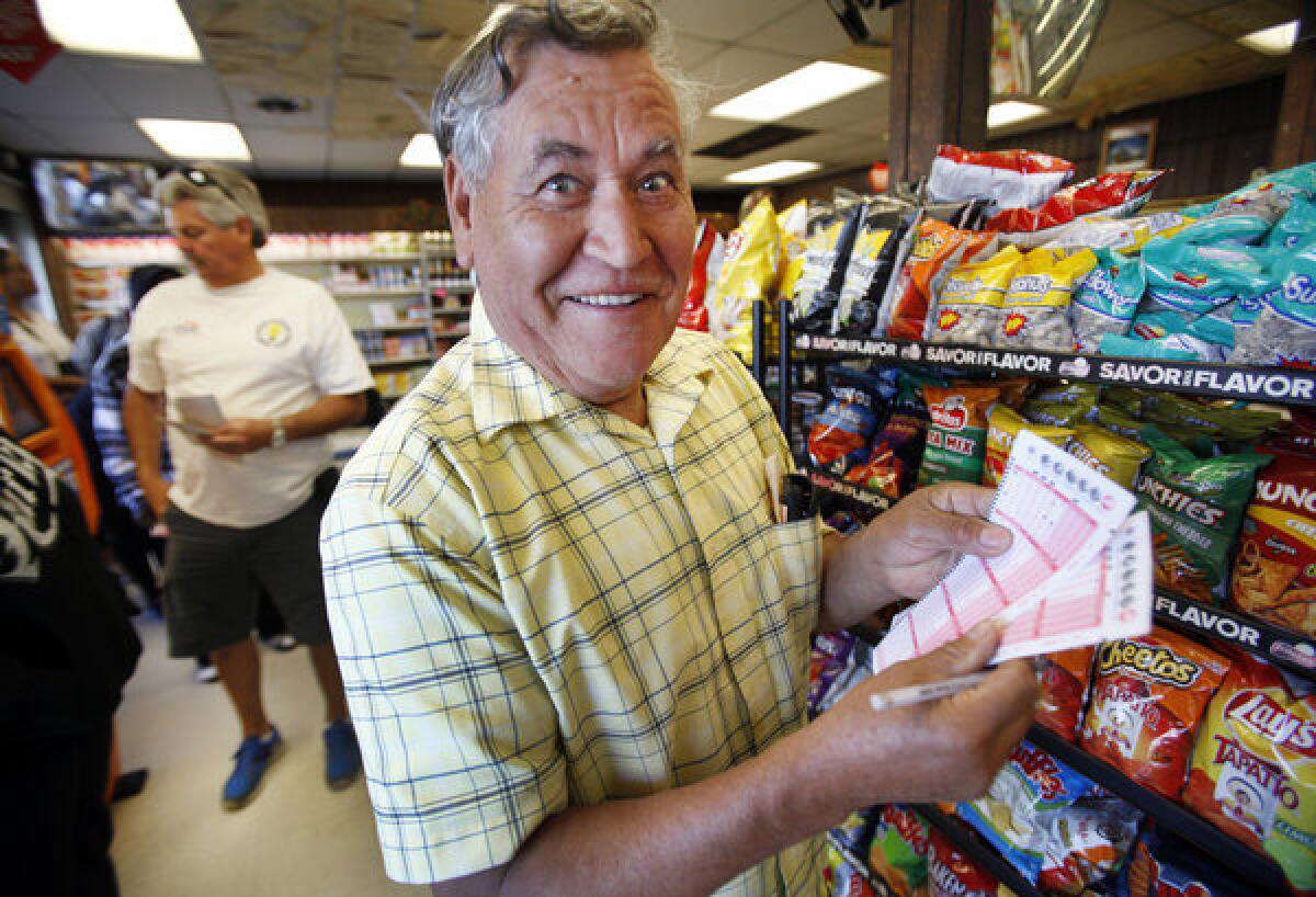 Rafael Moreno picks his lucky numbers for the Powerball drawing at Bluebird Liquor in Hawthorne on Monday.