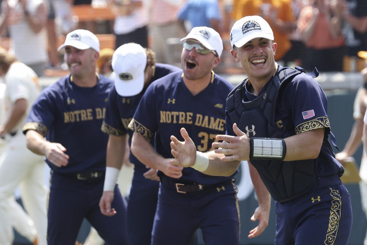 Notre Dame catcher David LaManna, right, celebrates with teammates after defeating Tennessee in an NCAA college baseball super regional game Sunday, June 12, 2022, in Knoxville, Tenn. (AP Photo/Randy Sartin)