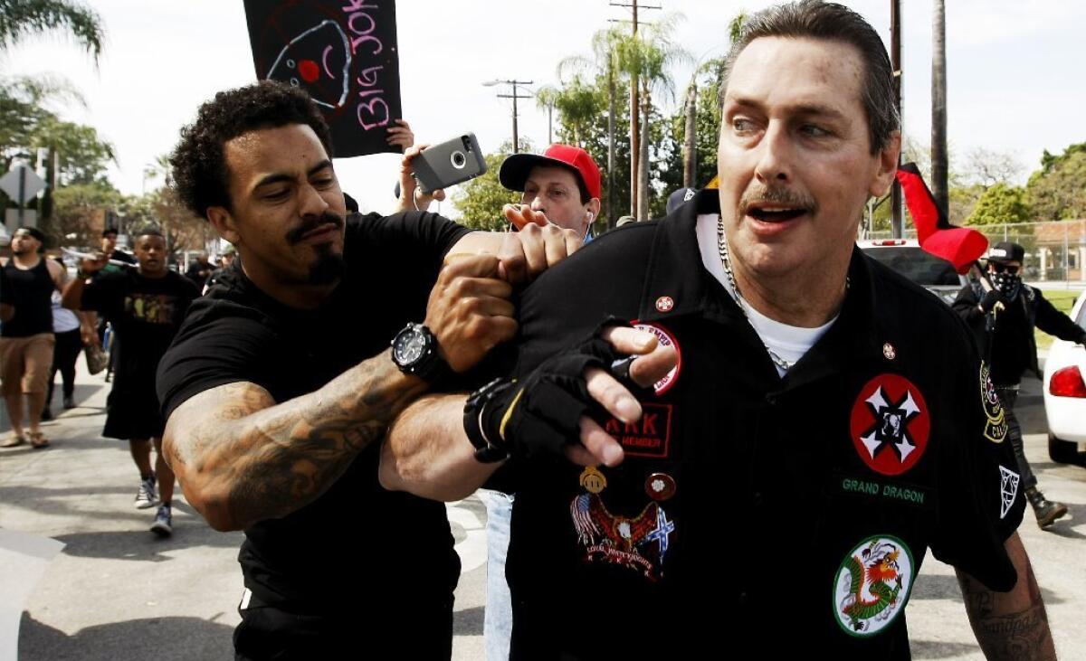 William Hagen, right, at a Ku Klux Klan rally in Anaheim, was arrested and charged with assault with a deadly weapon in North Carolina.