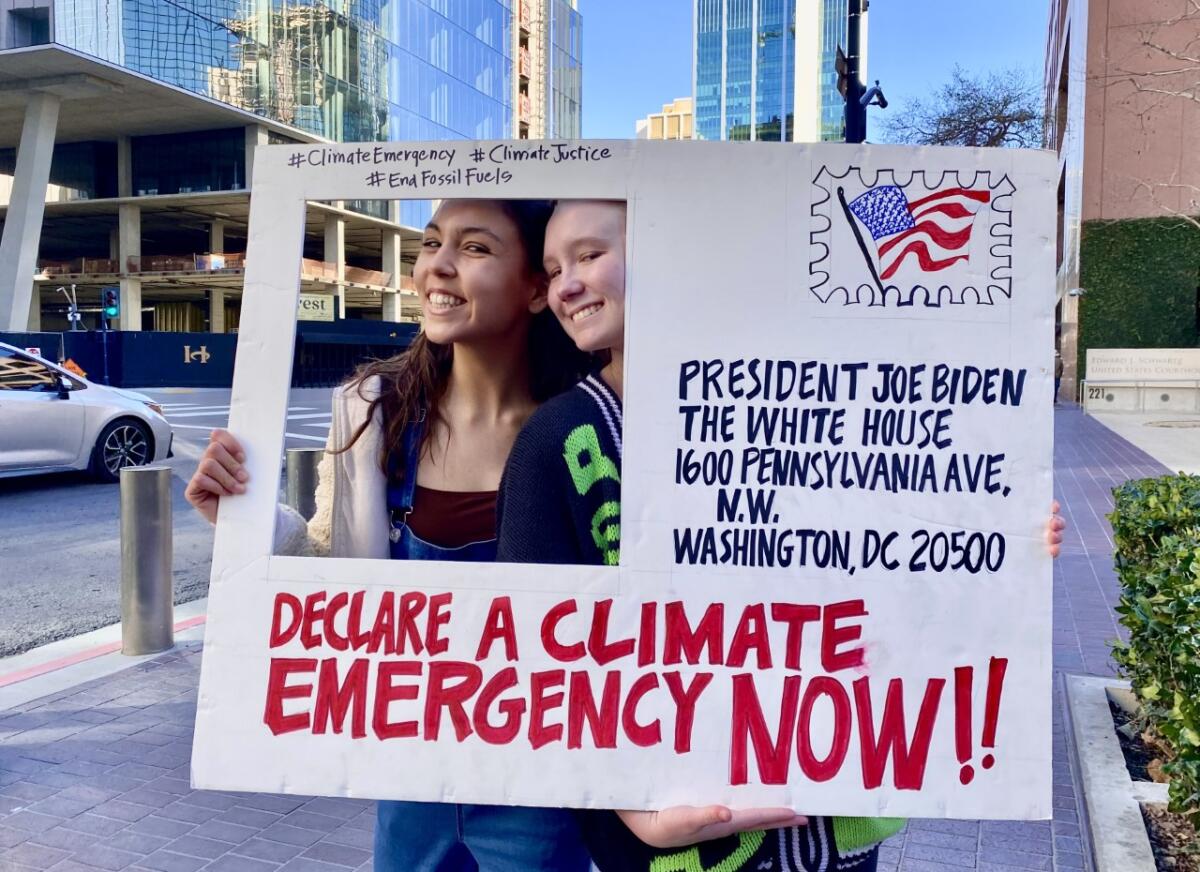 Sydney Kroonen (left) and Ryan Berberet took part in a protest Jan. 21 in San Diego urging climate action by President Biden.