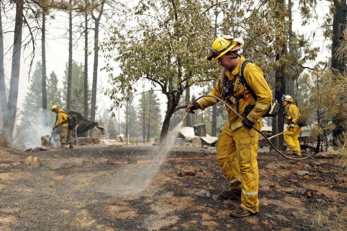 Matt Rietenbach hoses down hot spots left behind by the Eiler fire.