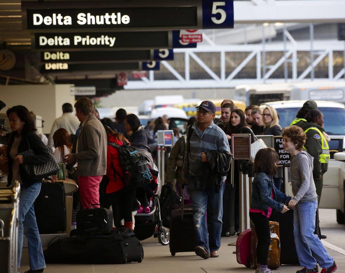 Passengers line up outside LAX Terminal 5 on Wednesday as flight delays and bad weather on the East Coast threatened to disrupt travel plans.