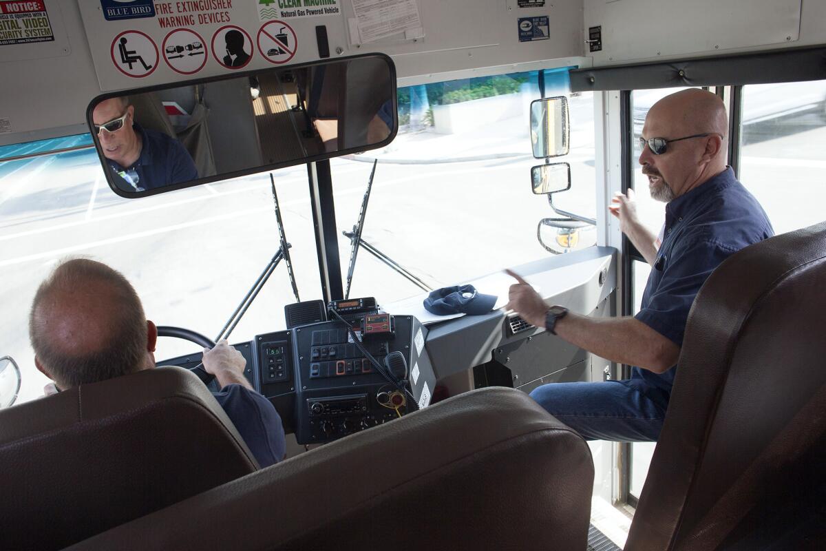 Victor Garza, right, a Delegated Behind the Wheel Trainer, directs trainee Steve Larson through local neighborhoods near South Coast Plaza on Aug. 19. Garza represented California in the 45th annual School Bus Driver International Safety Competition and took first place in the transit category.