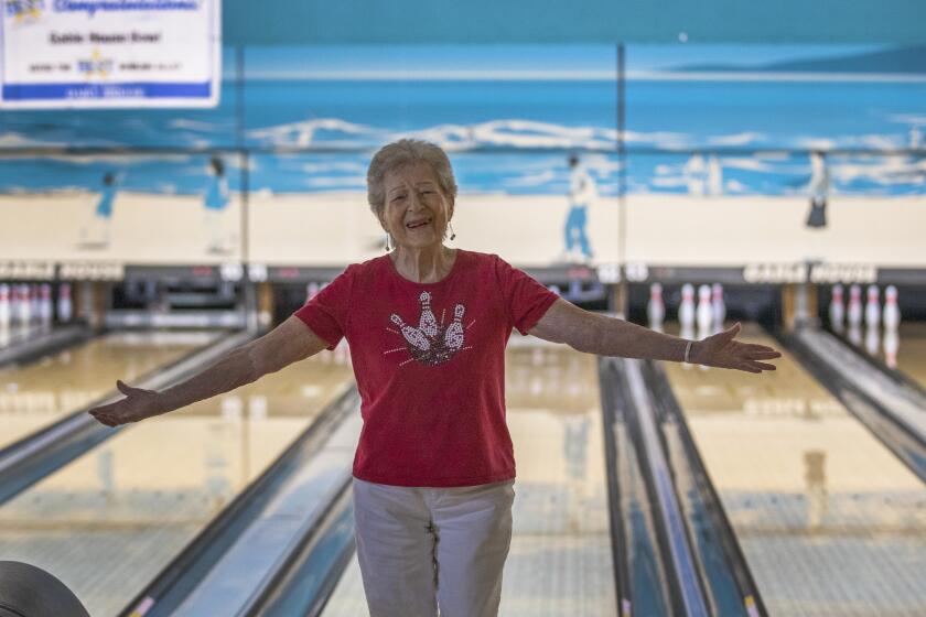 TORRANCE, CALIF. -- WEDNESDAY, AUGUST 28, 2019: Lillian Solomon, who is turning 100 on Sept. 18, celebrates getting a strike for her team, ÒSpare MeÓ, during the El Segundo Senior Summer League at Gable House Lanes in Torrance, Calif., on Aug. 28, 2019. Lillian has been living with her boyfriend Eddy Huyffer, 99, for 25 years in West Los Angeles. They left longtime dates after meeting, and moved in together. Eddy is taking a break from bowling due to a back injury, so heÕs serving as coach of LillianÕs team. (Allen J. Schaben / Los Angeles Times)