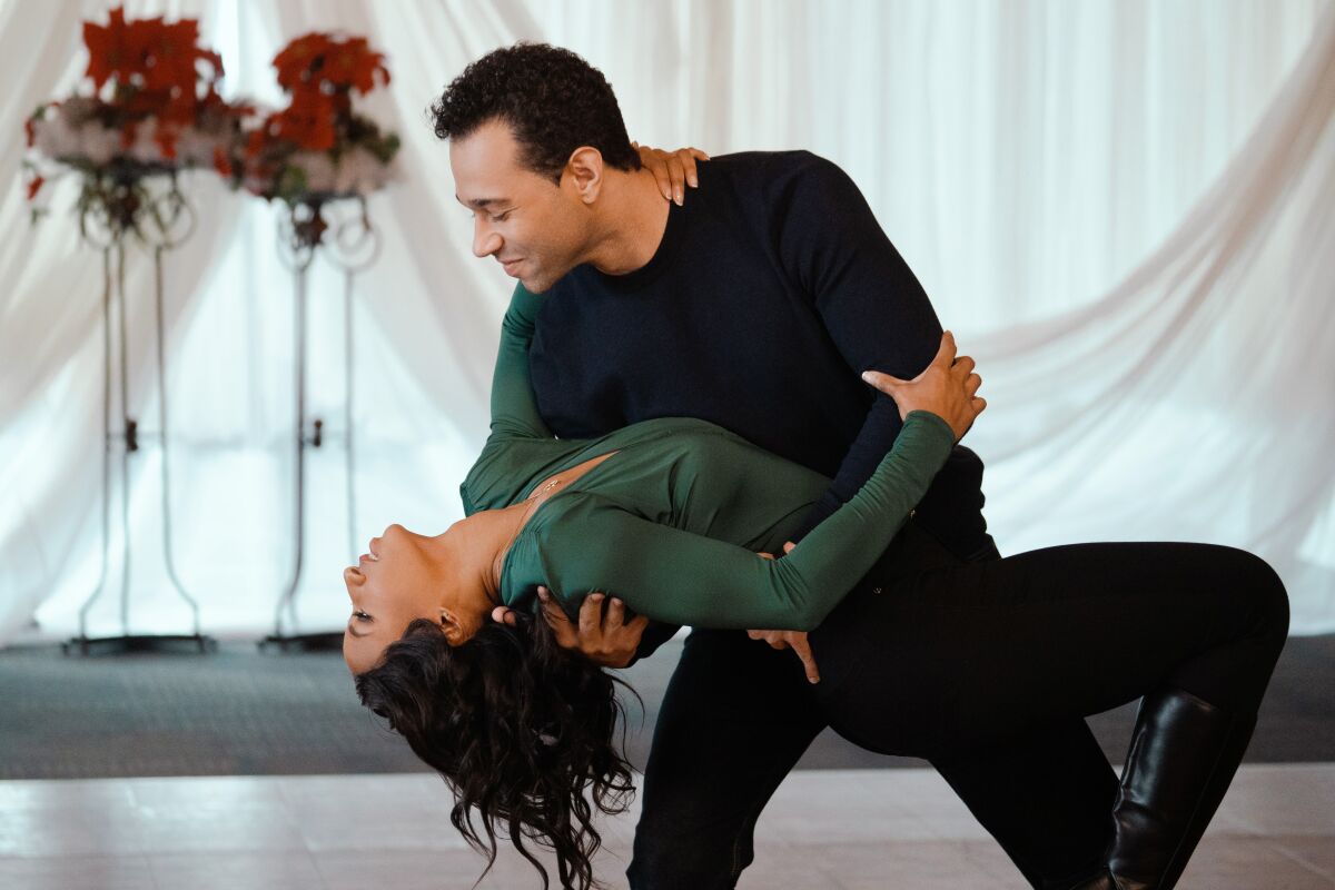 A man dips a woman as they dance together.