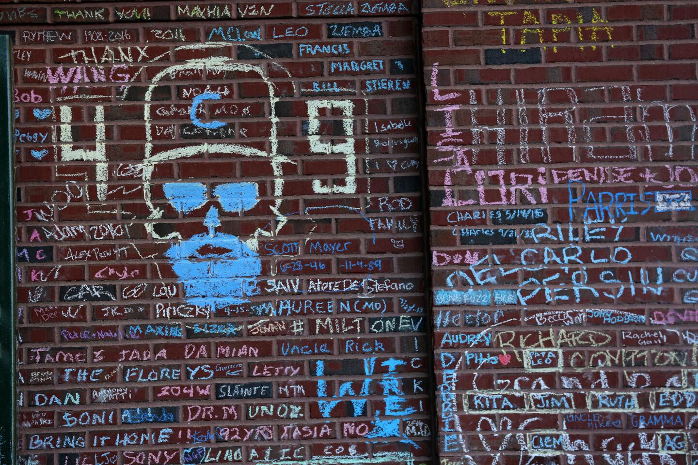 An image of Cubs manager Joe Maddon is chalked onto the wall on Waveland Avenue near the gate to the bleachers. Large crowds of fans showed up at Wrigley Field in Chicago to add to the chalk wall and take photos on Nov. 6, 2016.