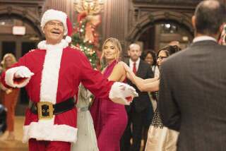 This image released by Lifetime shows Kelsey Grammer, left, and his daughter, Spencer Grammer in a scene from “The 12 Days of Christmas Eve." (Lifetime via AP)
