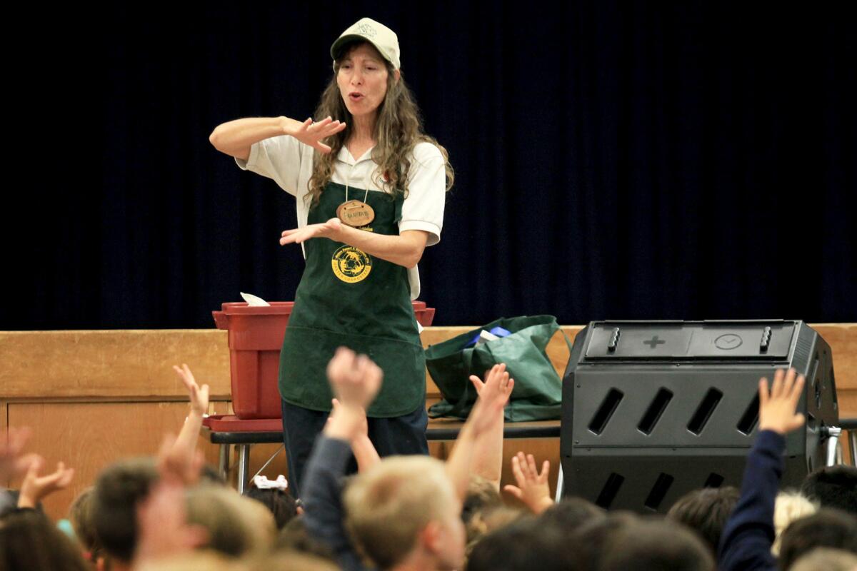 Francene Kaplan explains to group of kindergarteners how composting will help benefit their school's "Kinder Garden" during a presentation at Woodland Elementary School in Costa Mesa on Thursday. At right, one of three compost bins the Costa Mesa Sanitary District is offering for purchase. For more information Costa Mesa residents can visit cmsdca.gov.