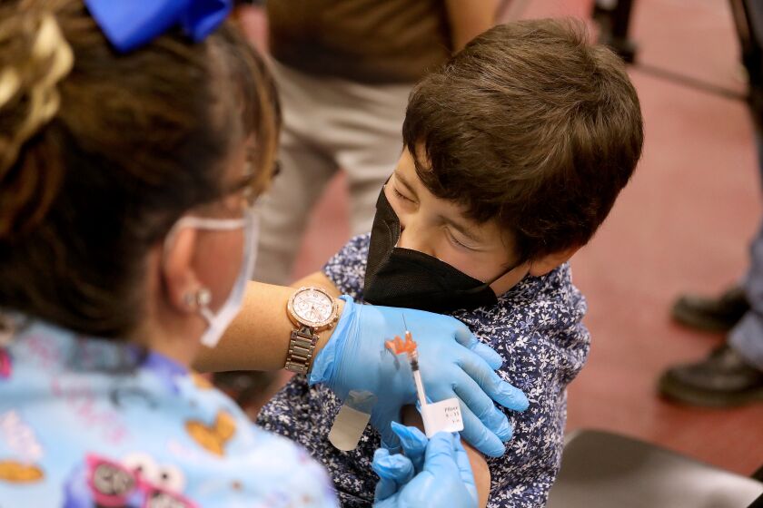 LOS ANGELES, CA - NOVEMBER 03: Luxiano (cq) Gonzalez, 8, of El Monte, receives a child's dose of the Pfizer vaccination from LVN Jacqueline Valdez at Eugene A. Obregon Park on Wednesday, Nov. 3, 2021 in Los Angeles, CA. The County of Los Angeles, including Supervisor Hilda L. Solis, Dr. Barbara Ferrer, Director of Public Health, and Norma Edith Garcia-Gonzalez, Director of Parks and Recreation, will host a media event kicking off COVID-19 vaccinations for children ages 5-11 in Los Angeles County. The COVID-19 vaccine manufactured by Pfizer and BioNTech is proposed to be given in two 10-microgram (mcg) doses administered 21 days apart. (Gary Coronado / Los Angeles Times)