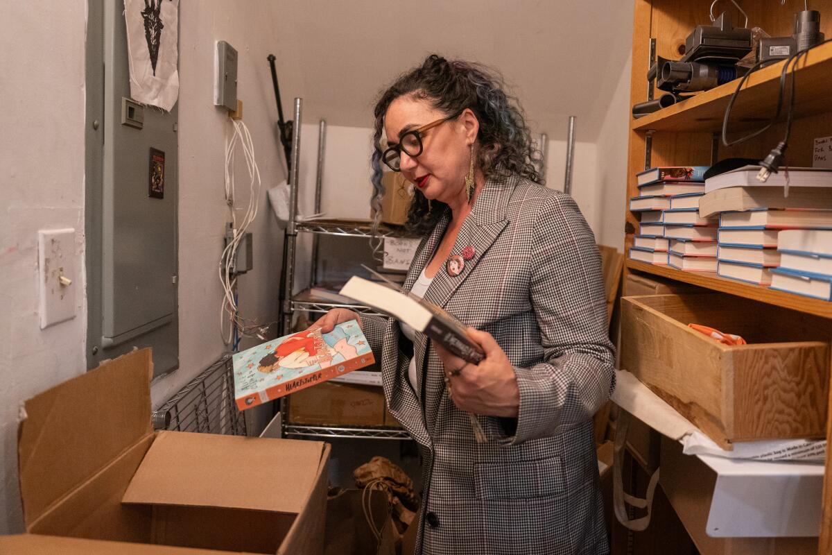 A woman puts books in a box.