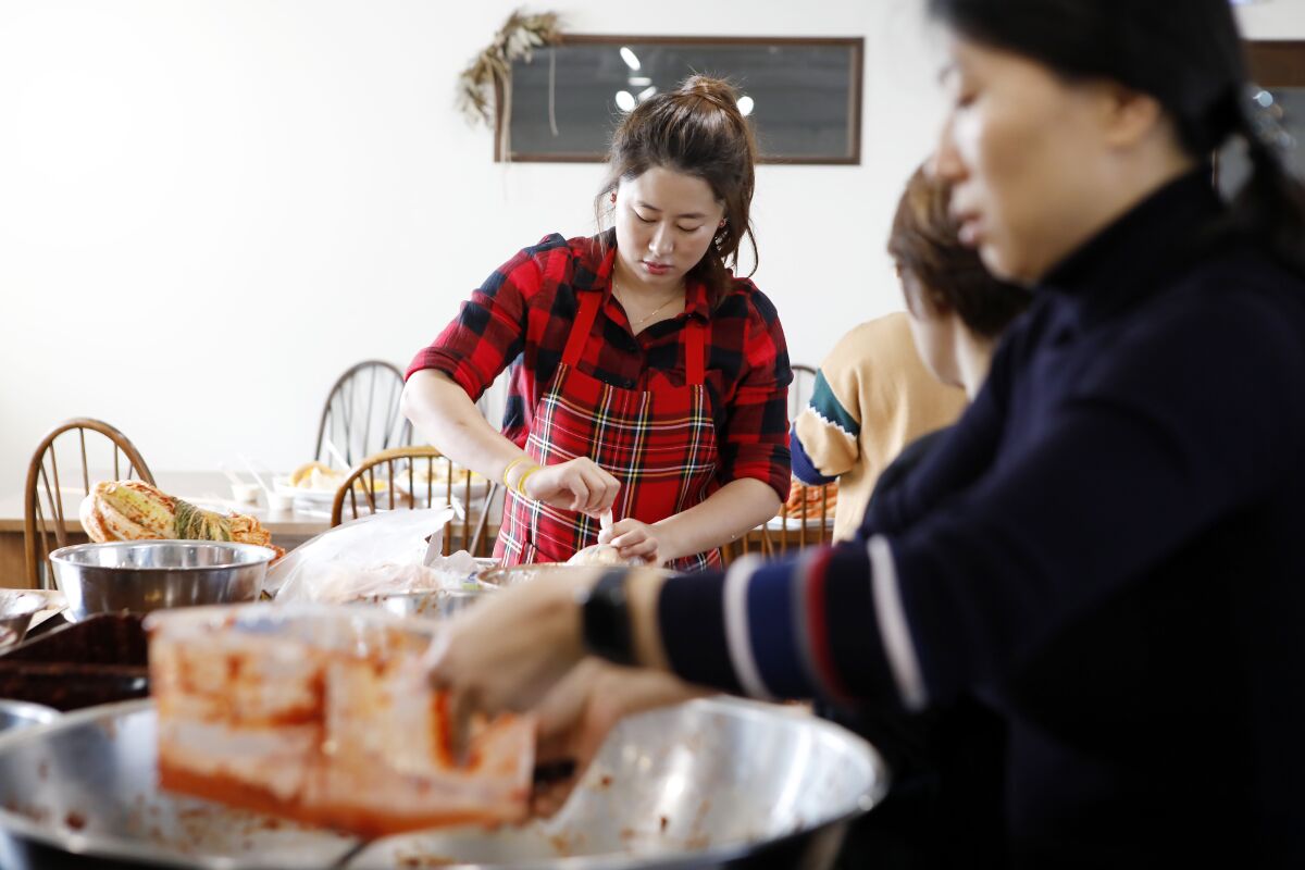 Jessie Kim wraps up the finished kimchi to be taken home by the students at her cooking class in November.