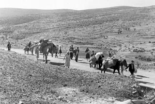 ARCHIVO - Un grupo de refugiados palestinos caminan de Jerusalén a Líbano con sus pertenencias el 9 de noviembre de 1948. (AP Foto/Jim Pringle, Archivo)
