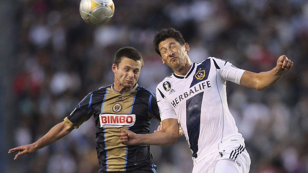 Jack McInerney, left, and Galaxy's Omar Gonzalez battle for a high ball in the first half during a match in 2012. The Galaxy has acquired McInerney.