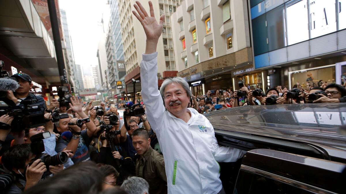 Hong Kong's former financial secretary, John Tsang, waves to supporters on March 24, 2017. Hong Kong is poised to choose a new leader Sunday, selected by a committee of elite members. (Kin Cheung / AP)