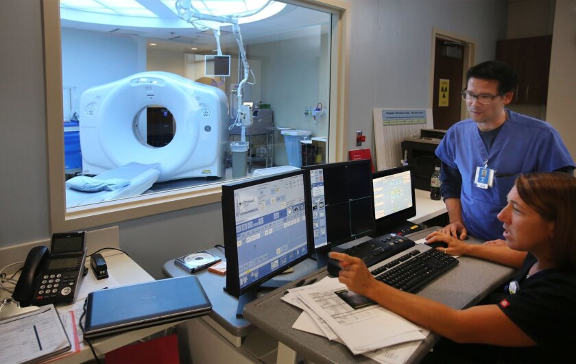 Radiology supervisor Geremy Bambakakis and CT technologist Jennifer Sigler work with a CT scanner in the new critical care building at Scripps Memorial Hospital in Encinitas. / photo by Bill Wechter * U-T San Diego