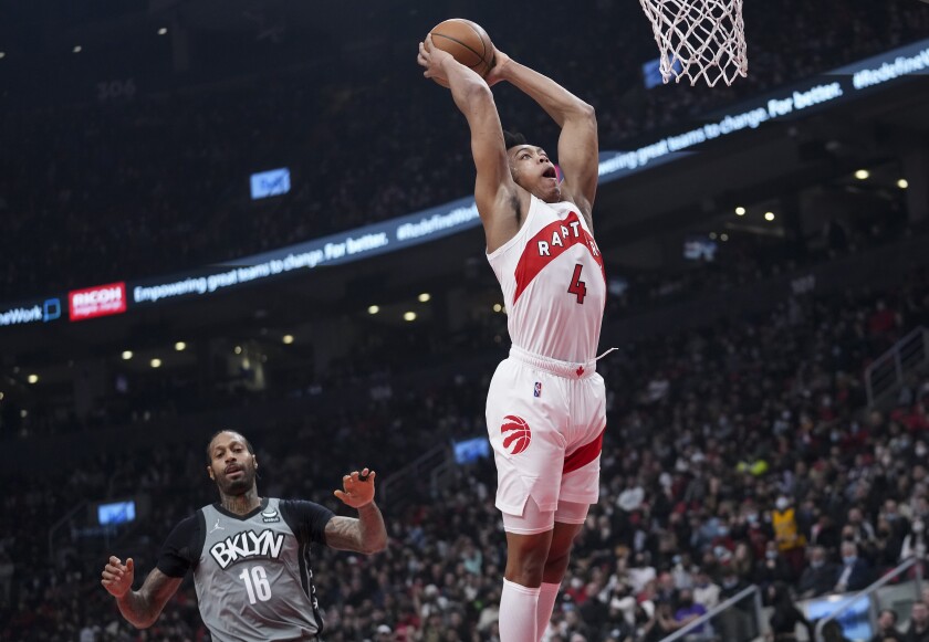 Toronto Raptors forward Scottie Barnes dunks in front of Brooklyn Nets forward James Johnson (16) during the first half of an NBA basketball game Tuesday, March 1, 2022, in Toronto. (Nathan Denette/The Canadian Press via AP)