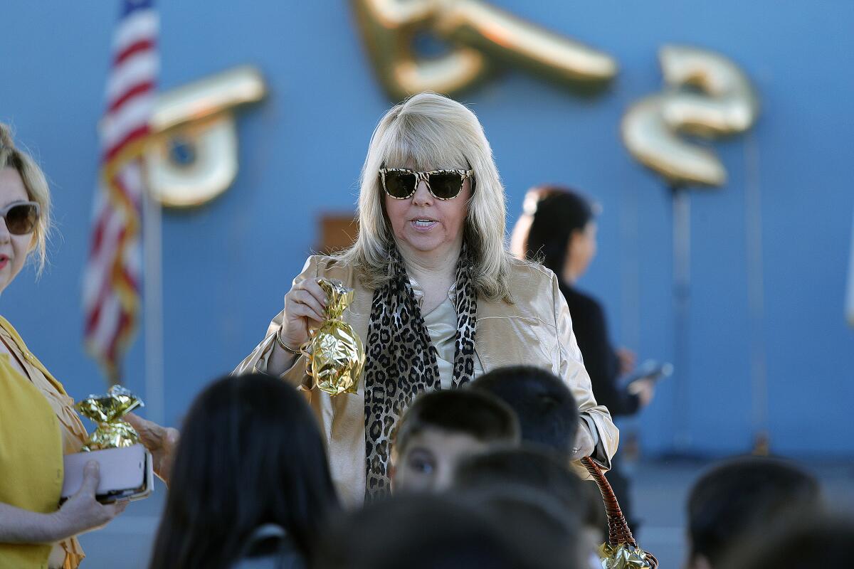 Former Principal Carla Walker hands out gold sacks with gold award wrist bands to each classroom at Marshall Elementary School on Monday. The school won a California Positive Behavioral Interventions and Supports gold medal and celebrated the recognition in the quad with the entire school along with members of the Glendale Unified School Board and the Glendale High marching band and color guard.