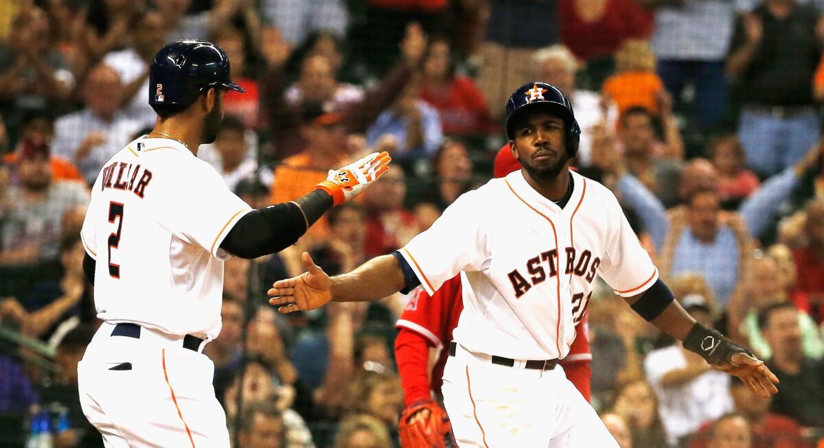 Jonathan Villar, left, and Dexter Fowler, right, celebrate after scoring two of the Astros' five runs in the third inning of the Angels' 7-2 loss to Houston.