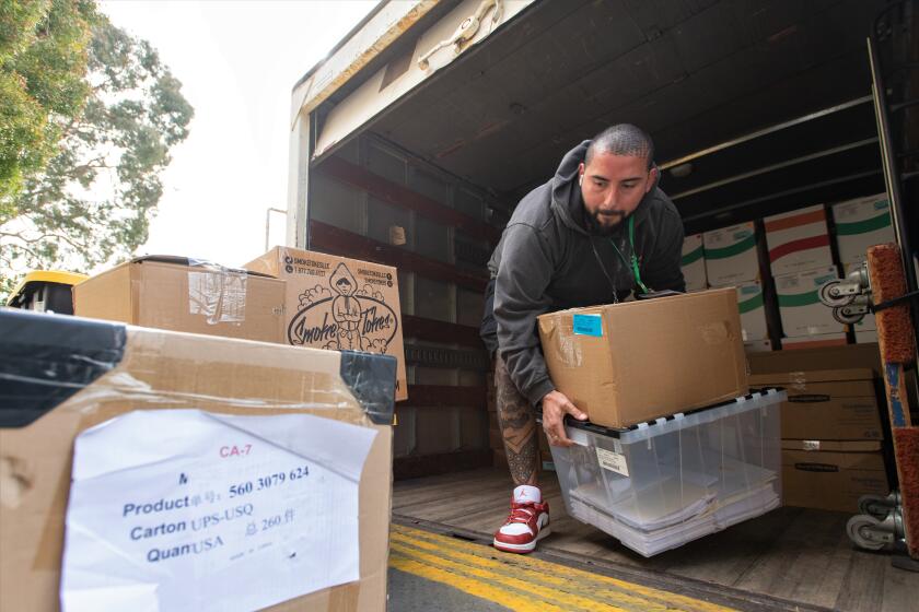 Se7enleaf Lab Director Mark Lopez helps unload  cannabis products and other items related to the business Thursday.