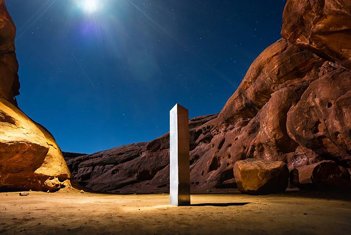 A metal monolith installed in the ground in a remote area of red rock in Utah. 