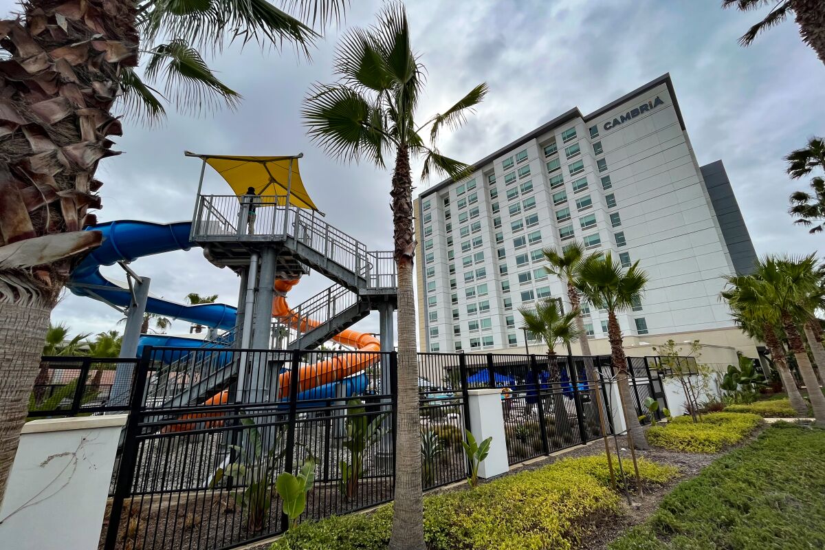 The exterior of a multistory hotel with playground equipment in the foreground