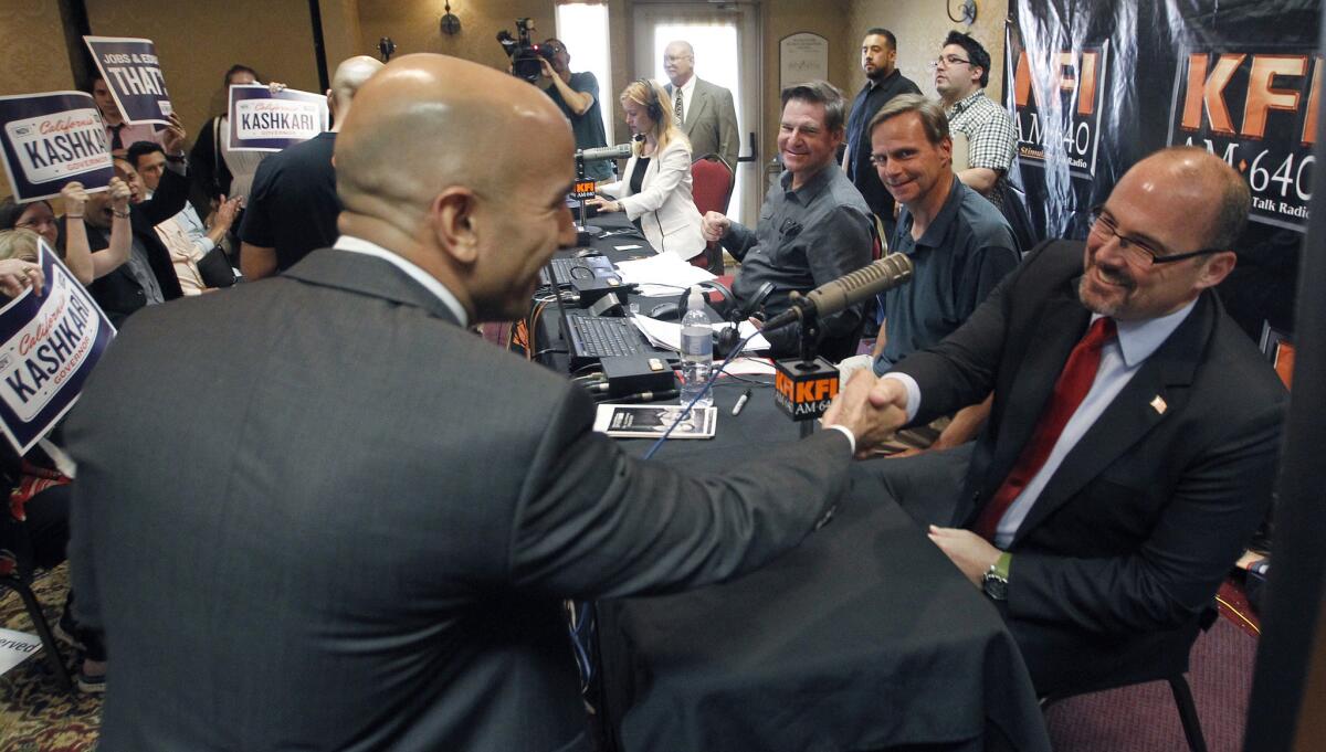 California Republican gubernatorial candidates Neel Kashkari, left, and Tim Donnelly shake hands at a radio debate in Anaheim earlier this month. A new Stanford University poll shows Donnelly leading his GOP rival in the bid to challenge Democratic Gov. Jerry Brown in November.