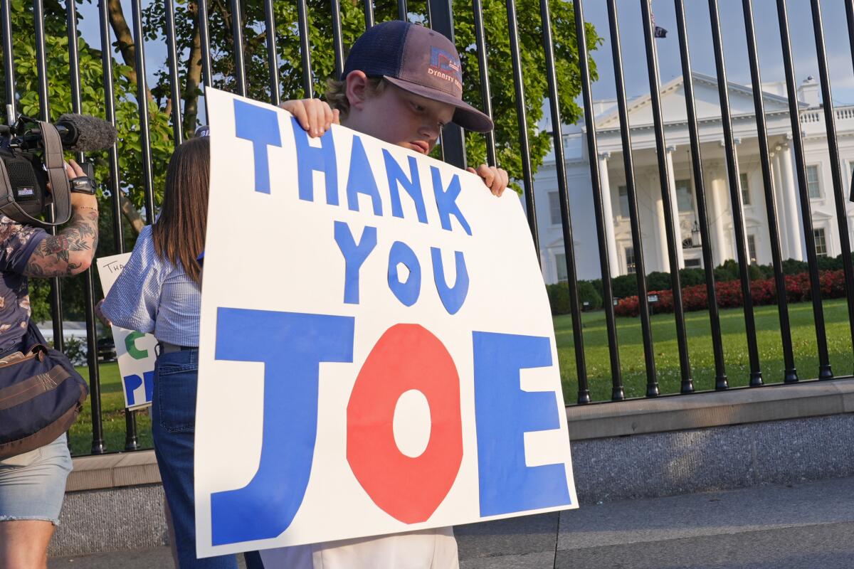 Hugh Kieve, de 10 años de edad, sostiene un letrero afuera de la Casa Blanca en Washington,