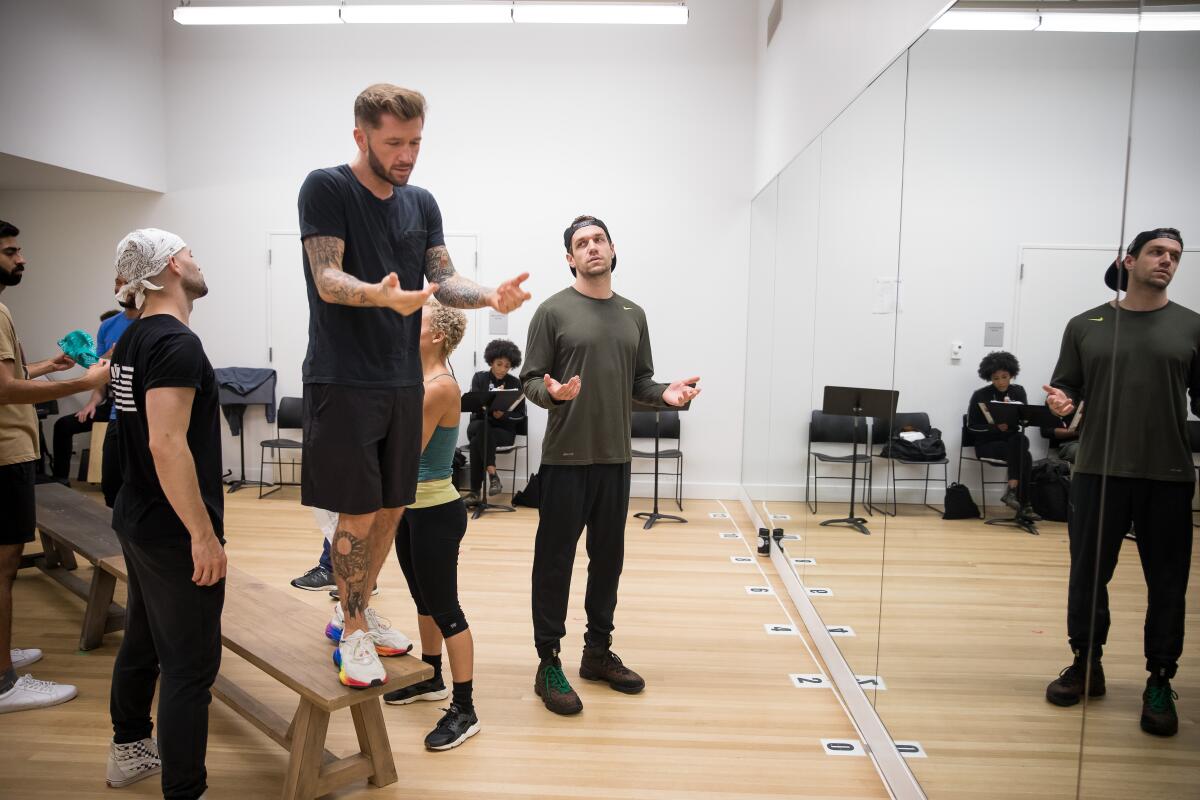 Choreographer Travis Wall, on a bench, with actor Ryan Vasquez and the cast of "The Wrong Man"