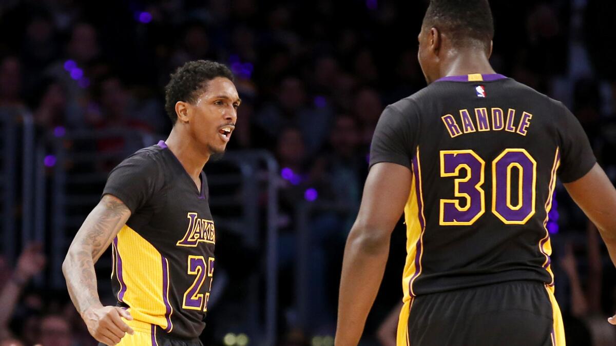 Lakers guard Lou Williams celebrates with forward Julius Randle after making a three-pointer against the 76ers in the second half Friday night.