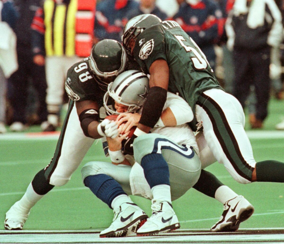 Cowboys quarterback Troy Aikman suffered a concussion on this 1997 play when sacked by the Eagles' Jimmie Jones, left, and William Thomas.
