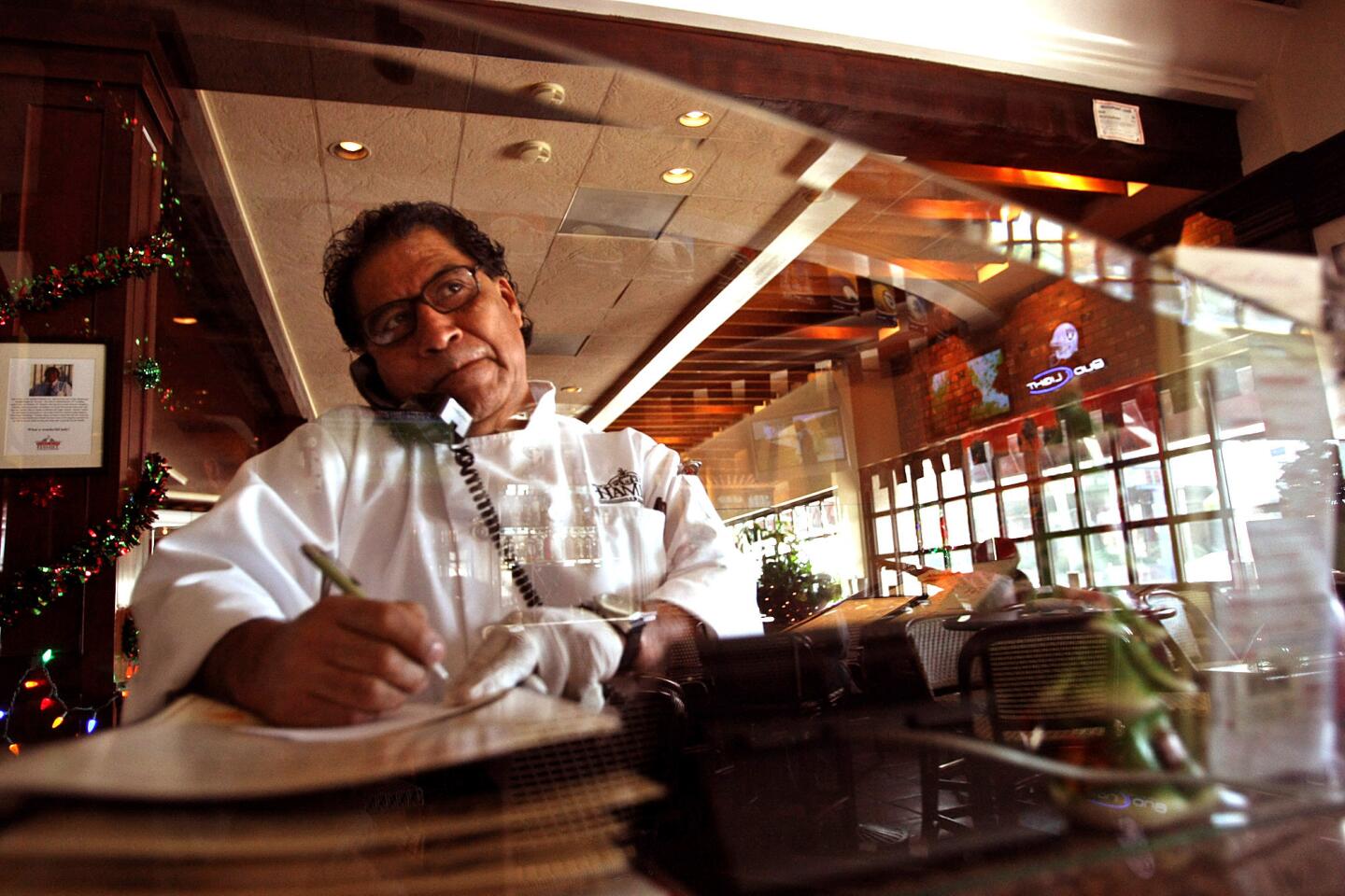Marcelino Martinez, 61, answers the phone at the Hamburger Hamlet he manages in Sherman Oaks. Martinez has spent 43 years at the once-prosperous chain that changed his life and the lives of many other Zapotec Indians from Oaxaca, Mexico.