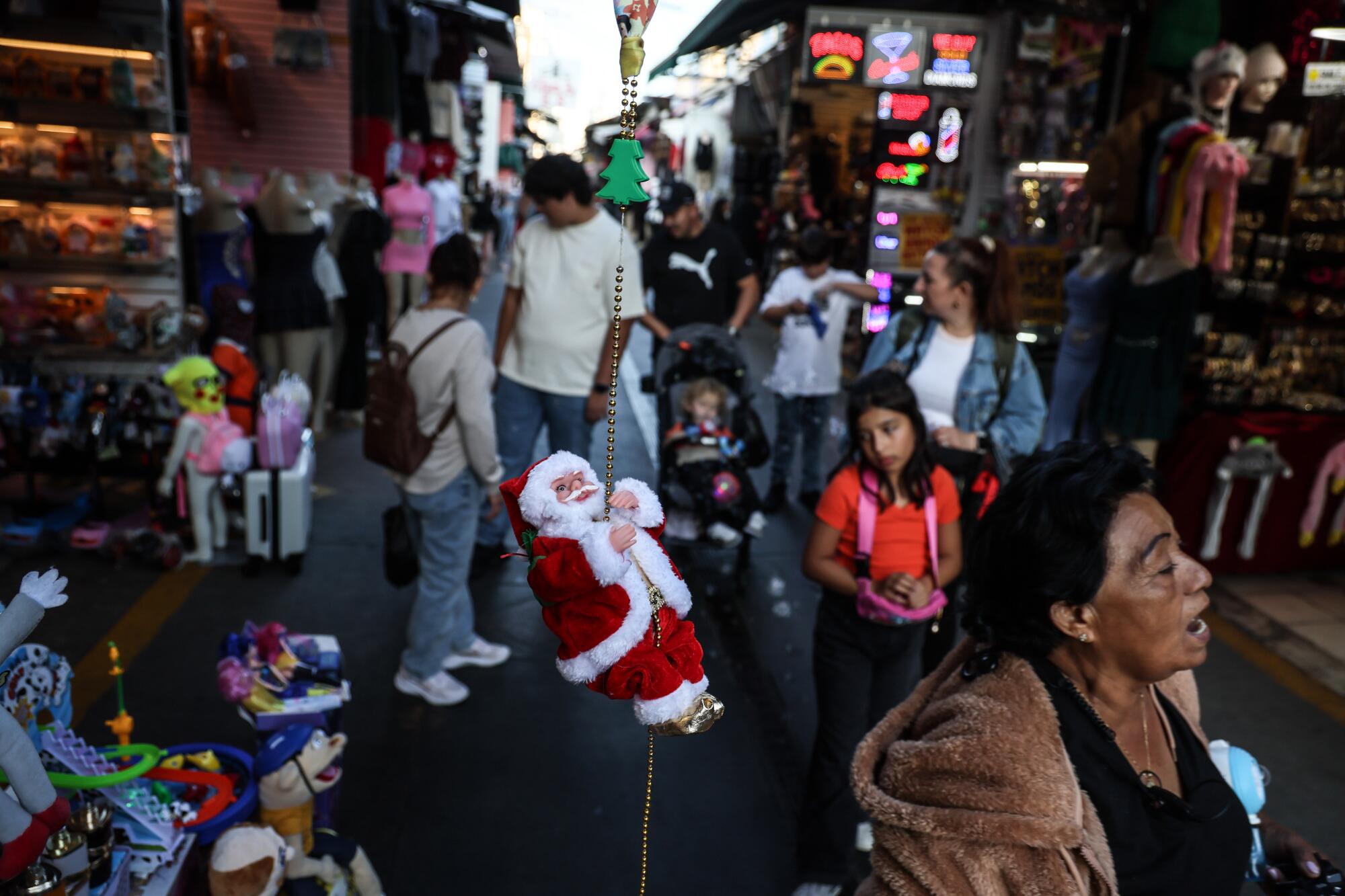 Shoppers stroll through The Santee Alley in downtown's fashion district