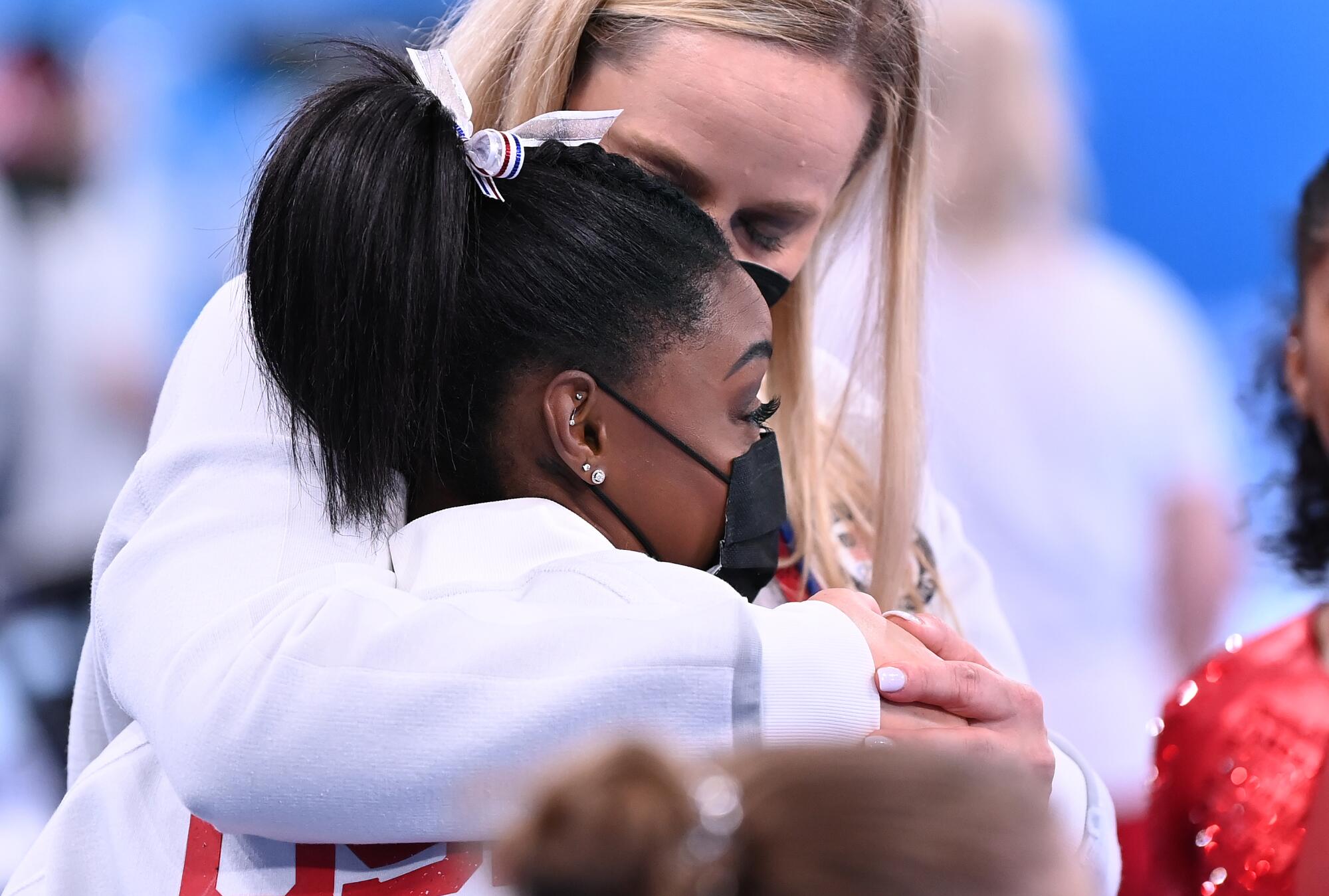 U.S. gymnast Simone Biles is consoled after withdrawing from the women's team final.