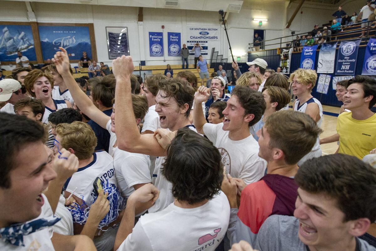 Dayne Chalmers, center, and the rest of his Newport Harbor teammates are swarmed by students after beating Los Angeles Loyola in the CIF Southern California Regional Division I semifinals in Newport Beach on May 16.