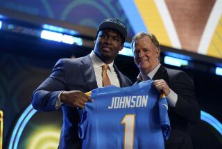Boston College offensive lineman Zion Johnson stands with NFL Commissioner Roger Goodell after being chosen by the Los Angeles Chargers with the 17th pick of the NFL football draft Thursday, April 28, 2022, in Las Vegas. (AP Photo/John Locher)