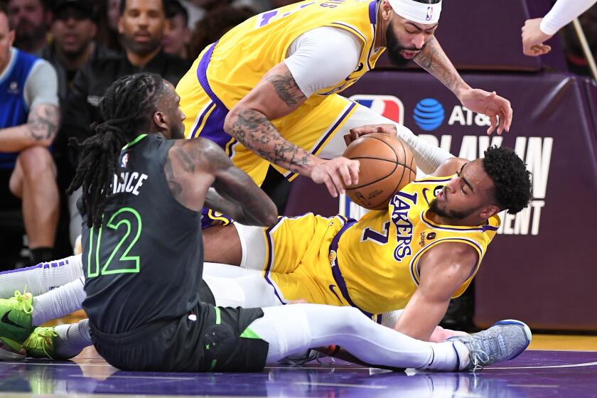 Los Angeles, California April 11, 2023-Lakers Troy Brown Jr., right, and Anthony Davis battle for loose all with Timberwolves Taurean Prince in the second quarter during a play-in game four the NBA playoffs at Crypto.com arena Tuesday. (Wally Skalij/Los Angeles Times)