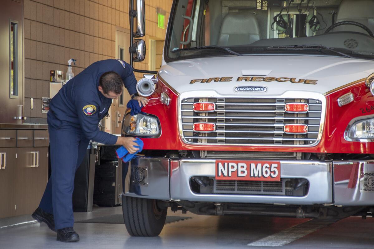 Firefighter Bryce Anderson polishes the fire rescue vehicle for the 9/11 anniversary ceremony on Saturday. 