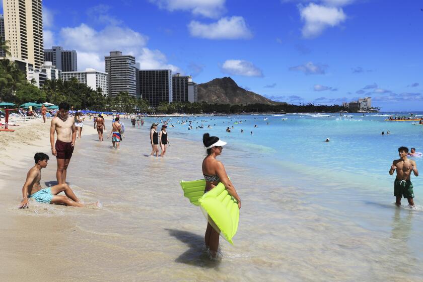 FILE - Beach goers take to the waves on Waikiki Beach on June, 23, 2022, in Honolulu. Hawaii lawmakers failed to pass a bill that would have made tourists help pay for the protection of Hawaii's forests and wildlife even though the idea has widespread public and political support. Lawmakers in the House and Senate failed to resolve their differences over the measure's details in time for a deadline at the end of this year's legislative session, which concludes on Thursday, May 4, 2023. (AP Photo/Marco Garcia)