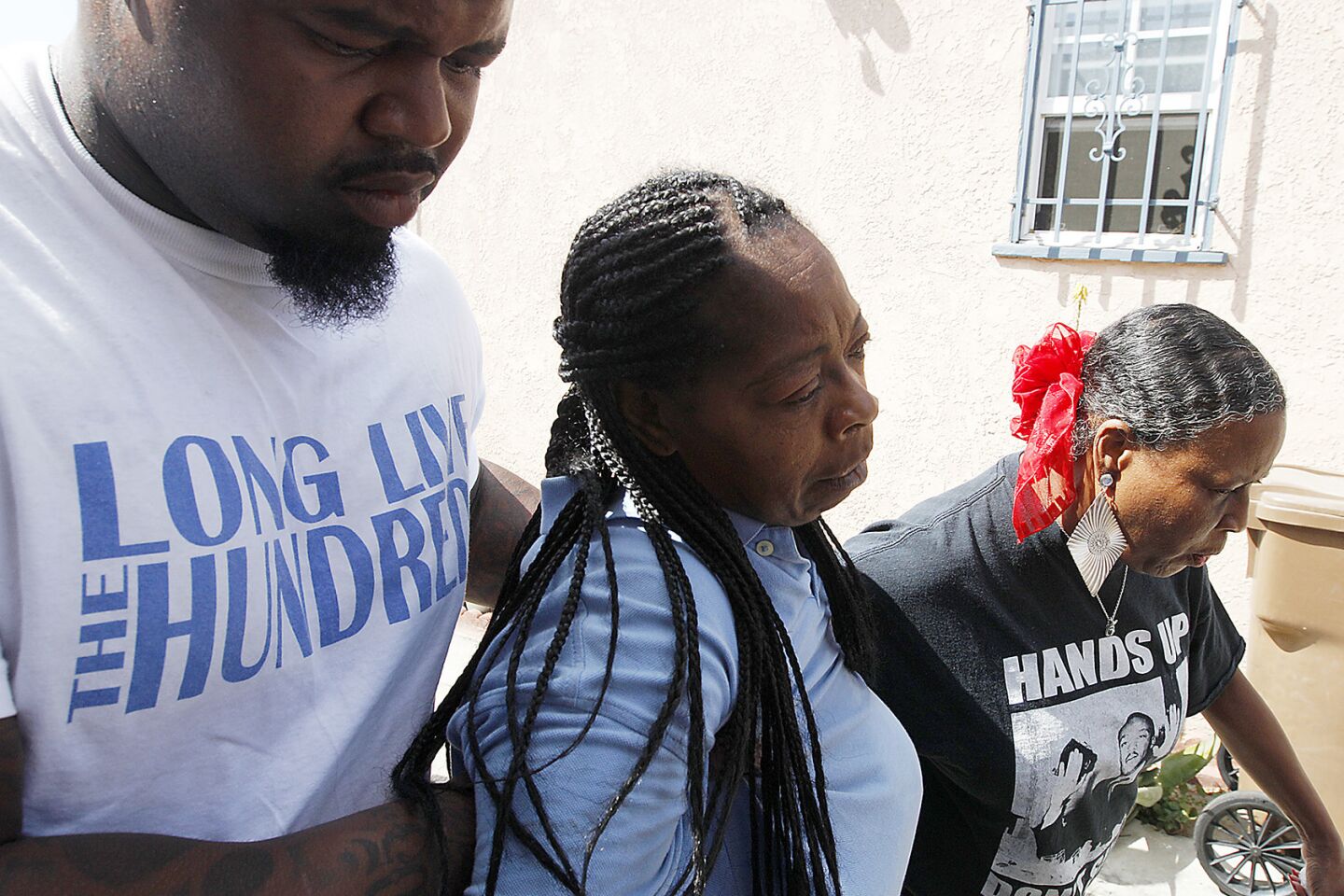 Neighbors brace a distraught Monique Morgan as she visits the scene where her son, Carnell Snell, 18, was fatally shot by police.