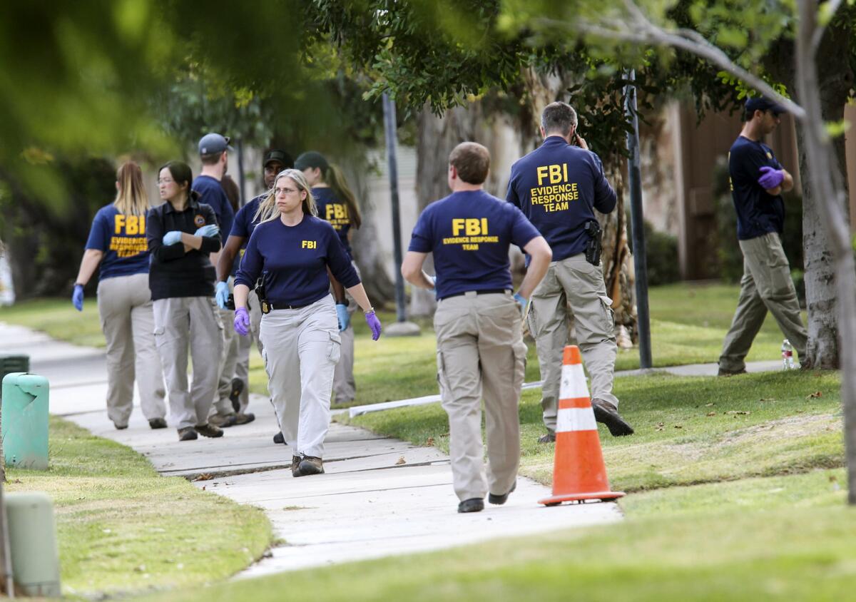 FBI agents search outside a home in connection to the shootings in San Bernardino on Dec. 3 in Redlands.