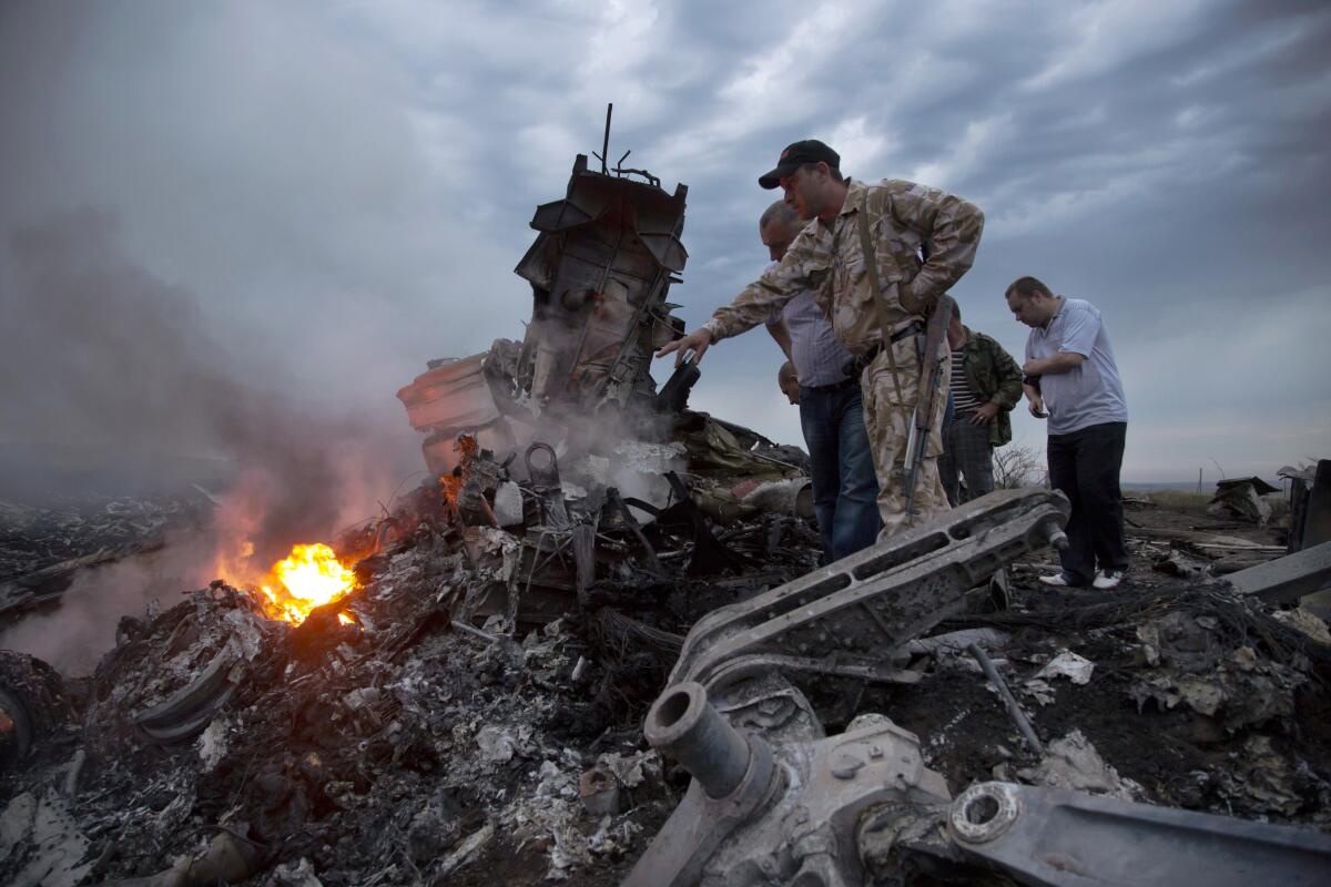 FILE - People inspect the crash site of a passenger plane near the village of Hrabove, Russian-controlled Donetsk region of Ukraine on Thursday, July 17, 2014. Europe's top human rights court ruled Wednesday, Jan. 25, 2023 that it can adjudicate on cases brought by the Netherlands and Ukraine against Russia for alleged rights violations in eastern Ukraine in 2014, including the downing of Malaysia Airlines flight MH17. (AP Photo/Dmitry Lovetsky, File)